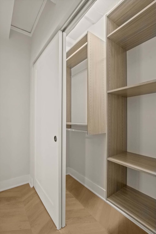 a walk in wardrobe with a sliding door in a bedroom