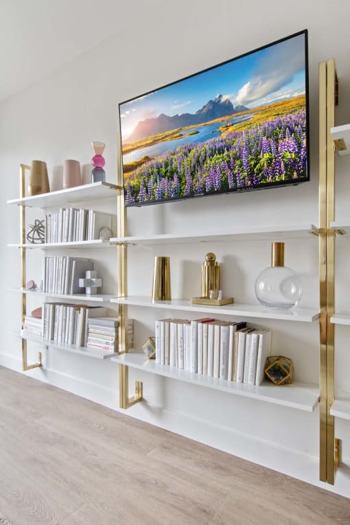 a bookshelf with a picture of a field of flowers on it