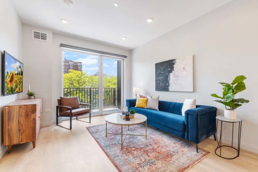 a living room with a blue couch and a sliding glass door