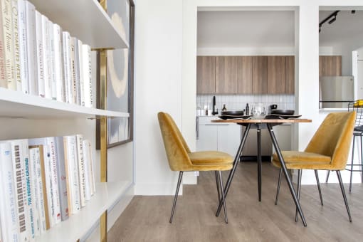 a dining room with a table and chairs and a book shelf