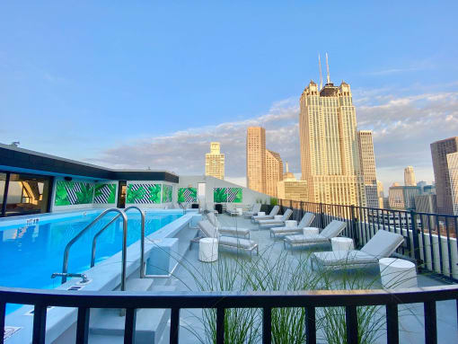 a pool on the roof of a building with a city in the background