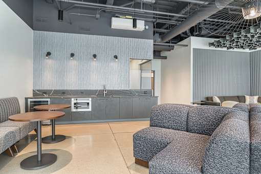 A modern living room with grey couches and a wooden table.