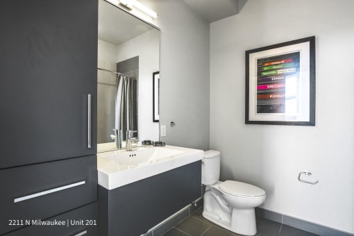 a bathroom with a sink toilet and a mirror