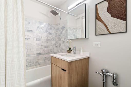 a small bathroom with a sink and a shower and a mirror