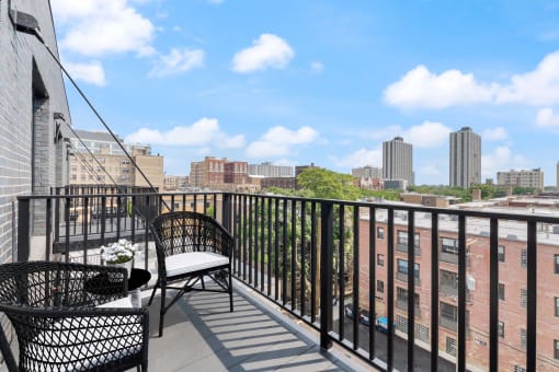 a balcony with two chairs and a view of the city