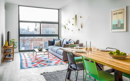 a living room with a large window and a wooden table