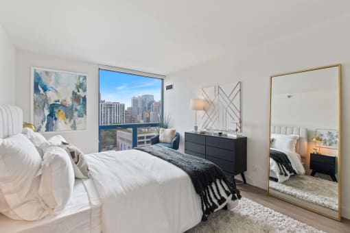 a bedroom with a bed and a large window