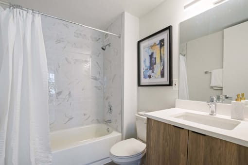 a bathroom with a shower sink and toilet and a mirror