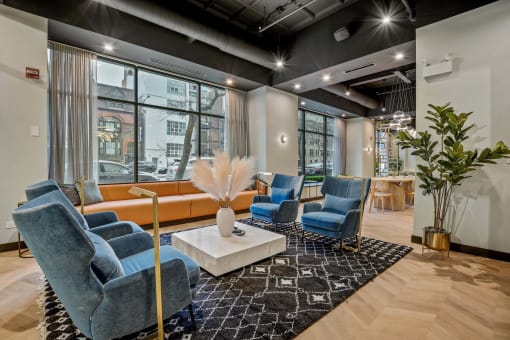 a lounge area with blue chairs and a white coffee table