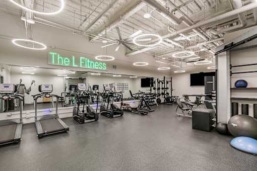 A gym with treadmills, exercise bikes, and other equipment.
