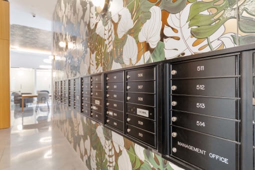 a long line of mailboxes in a room with a floral wallpaper