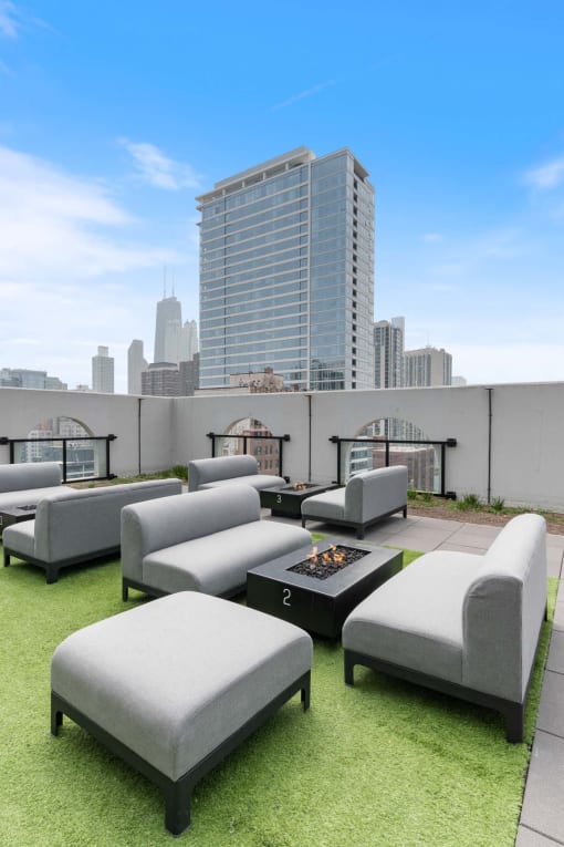 a roof top lounge area with a view of the city