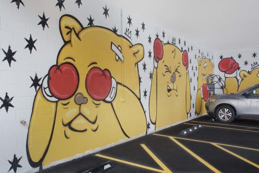 a mural on the wall of a parking lot with a car