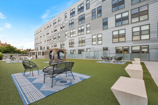 a courtyard with tables and chairs in front of a building
