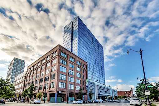 a tall building on a city street under a cloudy sky