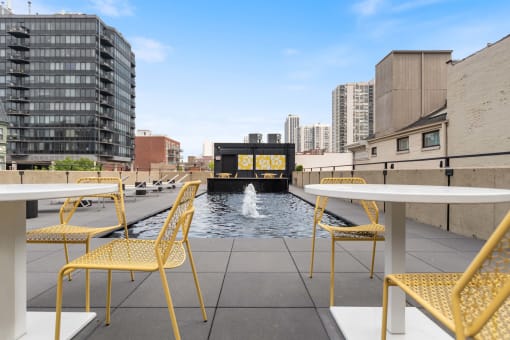 a roof terrace with tables and chairs and a fountain