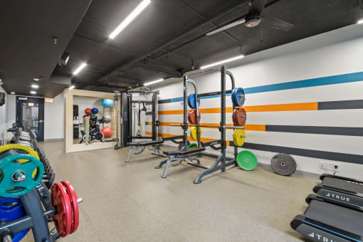 a gym with weights and a wall painted with a subway train