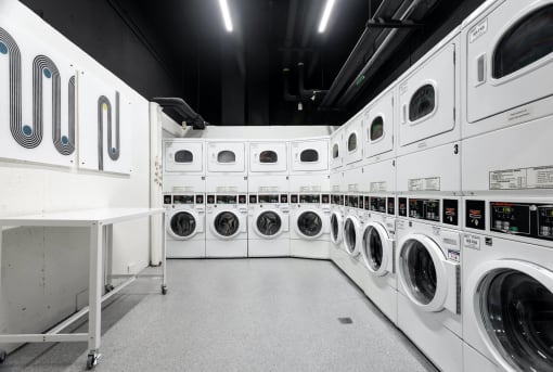 a row of washers and dryers in a laundry room