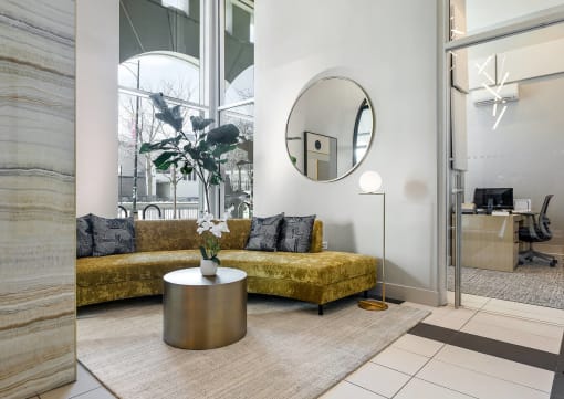 a living room with a couch and a round mirror