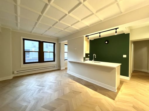 an empty room with a sink and a green wall and a window