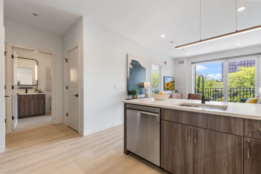 a kitchen with an island and a door to a living room