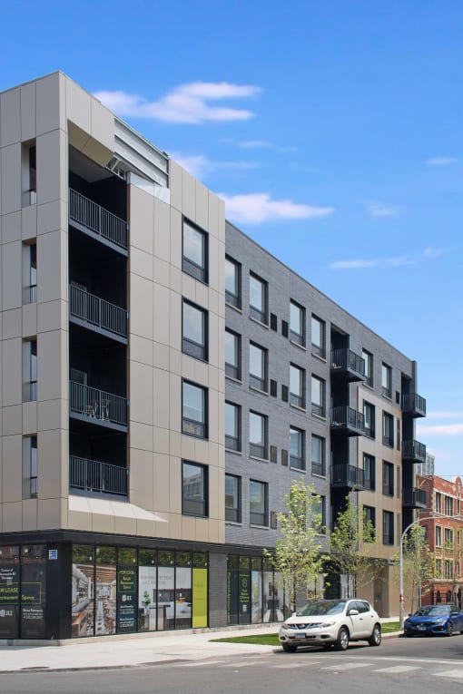 a new apartment building on a city street with a car