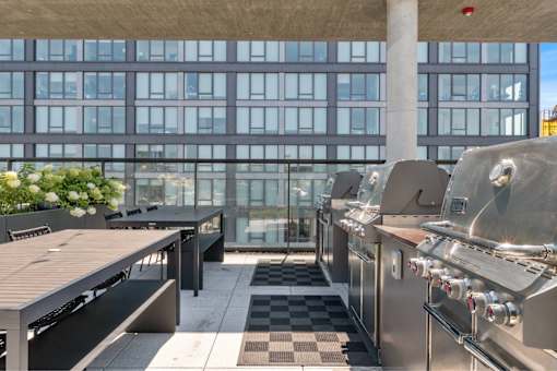 A modern outdoor kitchen with stainless steel appliances and a checkered floor.