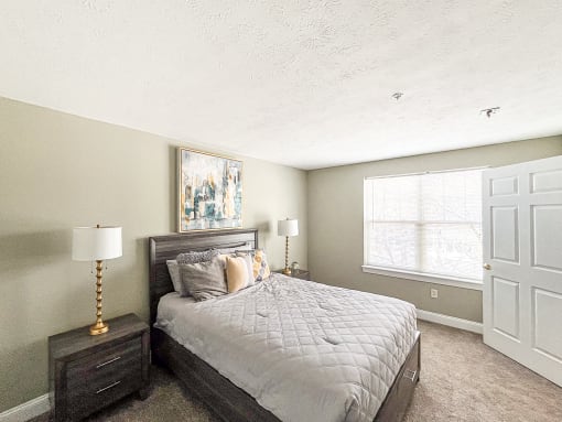 Spacious 1st-floor bedroom of loft apartment with large, bright windows