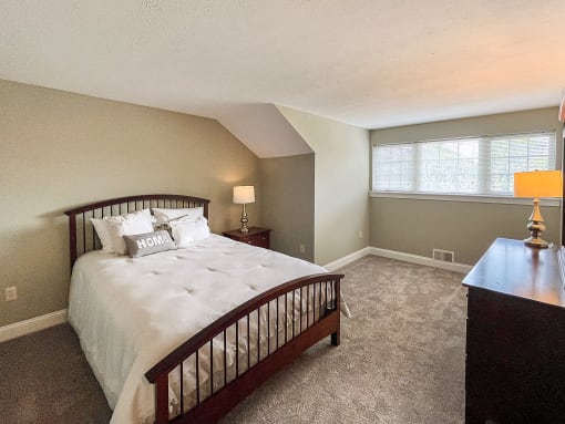Spacious upstairs bedroom in 2-story apartment with large windows
