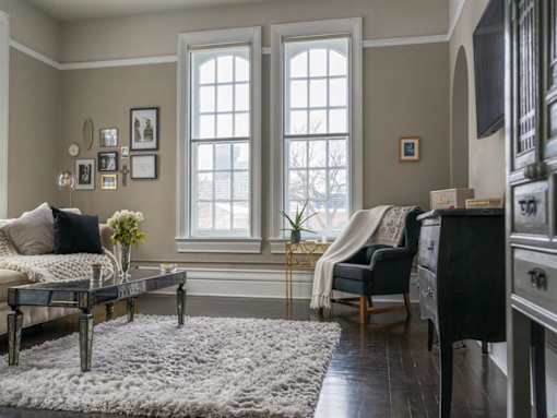 a living room with a couch and a table and two windows