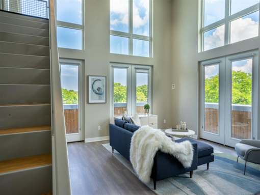 a living room with large windows and a blue couch