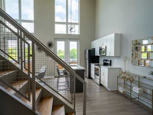 a kitchen and living room with a staircase