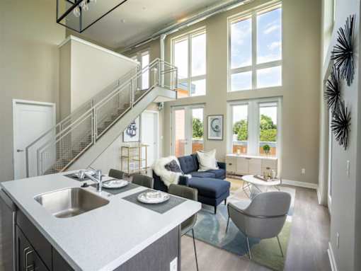 a living room with a kitchen and a staircase