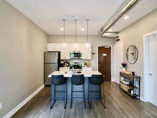 a kitchen with an island and three blue chairs
