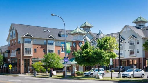 View of Corn Hill Landing from Exchange Boulevard showing street-level shops and restaurants as well as apartments above and entryway clock tower View of Corn Hill Landing from Exchange Boulevard showing street-level shops and restaurants as well as apartments above and entryway clock tower