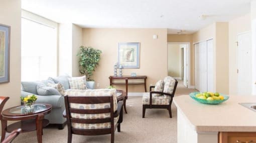 Spacious living room area in great room of 2-bedroom ranch style apartment with large, bright windows and hallway to 2nd bedroom in the background Spacious living room area in great room of 2-bedroom ranch style apartment with large, bright windows and hallway to 2nd bedroom in the background