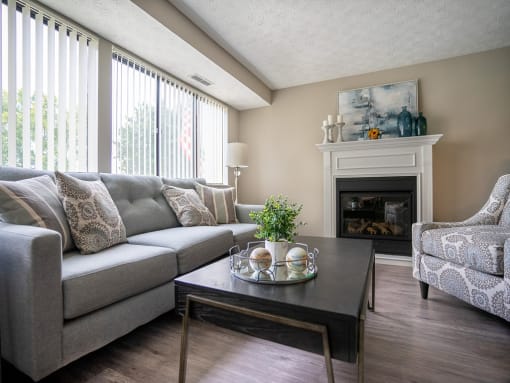 a living room with a couch and a table in front of a fireplace