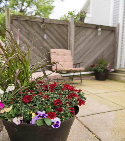 Typical patio with concrete pavers, fence, seating, and flowers