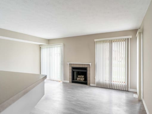 View of great room from kitchen area showing fireplace, faux-wood flooring, and slider to patio