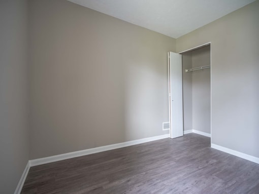 View of typical second bedroom with closet and faux plank flooring