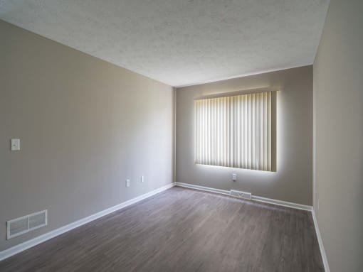 View of typical primary bedroom with large windows and faux plank flooring