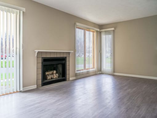 View of great room from dining area showing fireplace, faux-wood flooring, and slider to patio