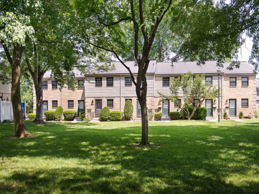Exterior view from treed courtyard of private entrances to apartment homes