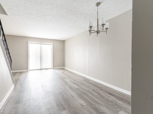 Interior of living/dining area with faux wood flooring viewed from the front entrance hall