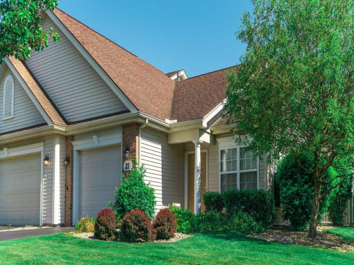 a house with a lawn and trees in front of it