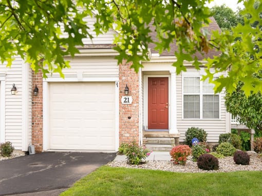 a house with a red door and two garage doors