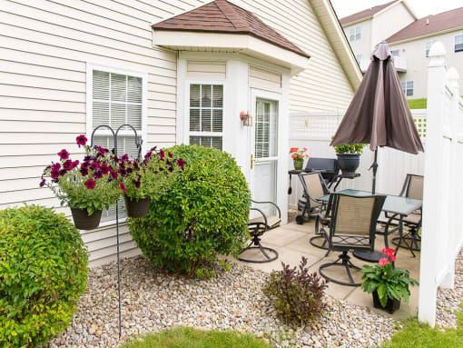 a backyard patio with a table and chairs and an umbrella