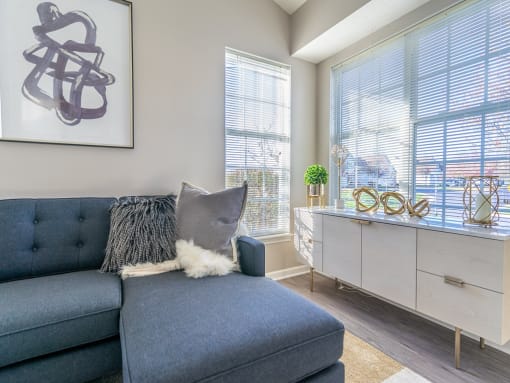 a living room with a blue couch and two windows