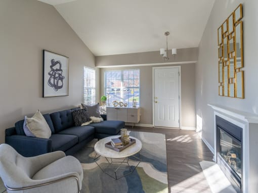 a living room with a couch and a chair and a fireplace
