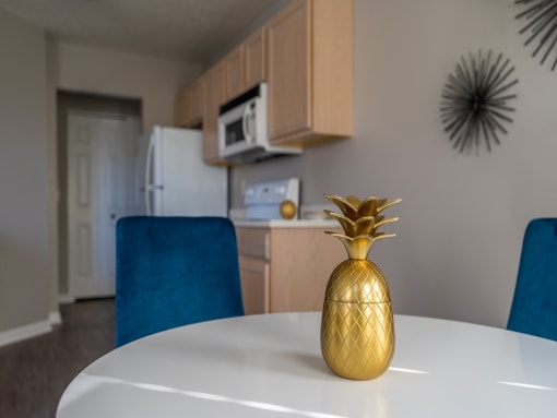 a dining room table with a gold vase on it